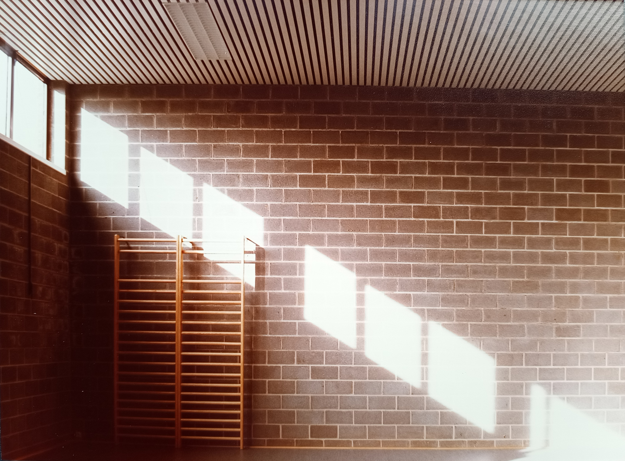 Gymnase intérieur, lumière naturelle sur mur brique